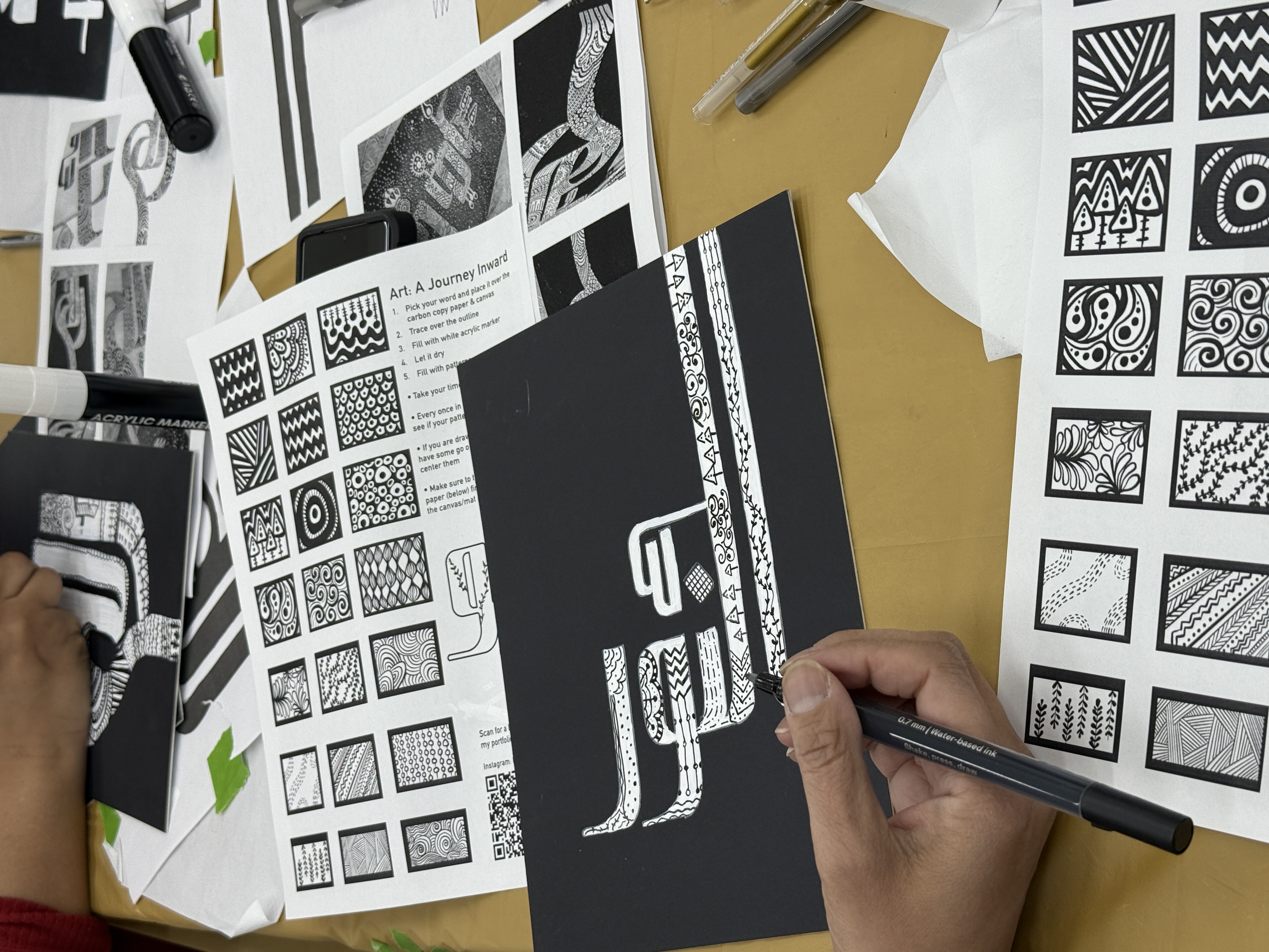 Participant filling calligraphy letterforms with pattern